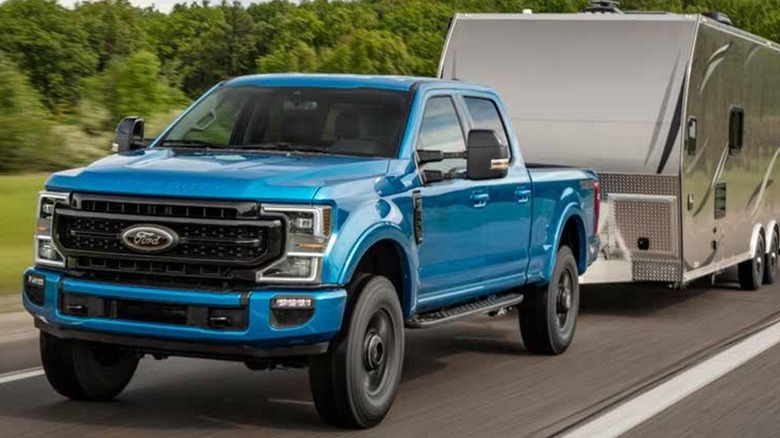 A blue Ford F-250 towing a camper