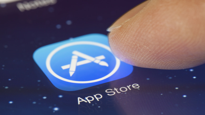 Finger tapping the App Store icon on a smartphone