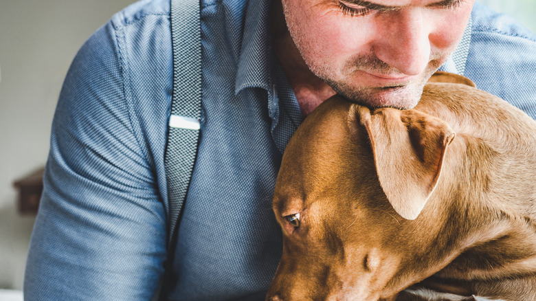 man hugging dog