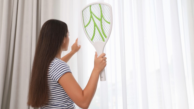 woman holding electric fly swatter