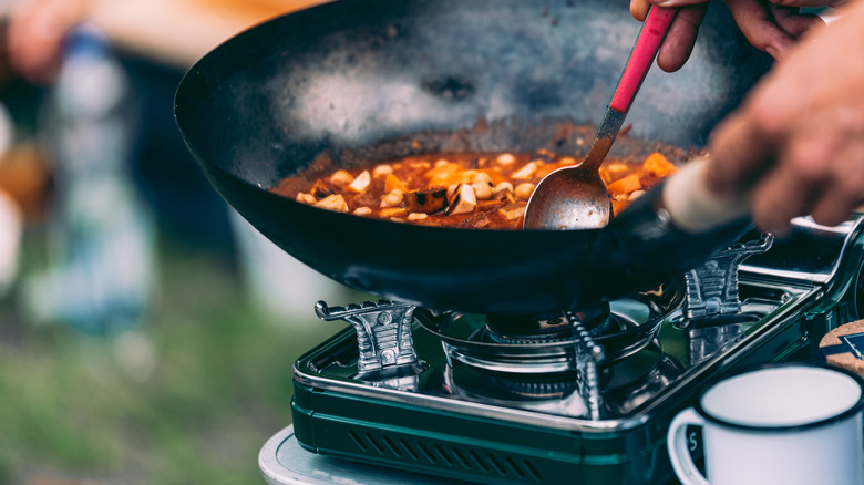 person cooking on camping stove