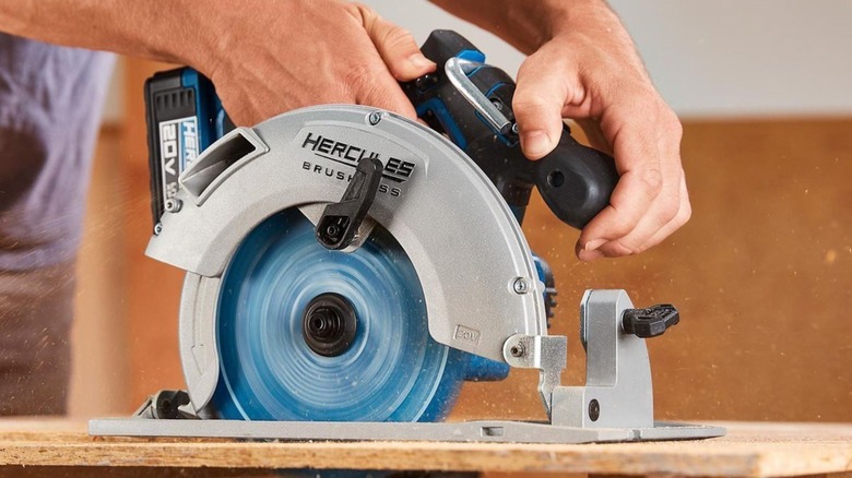 Person using a circular saw to cut a piece of wood