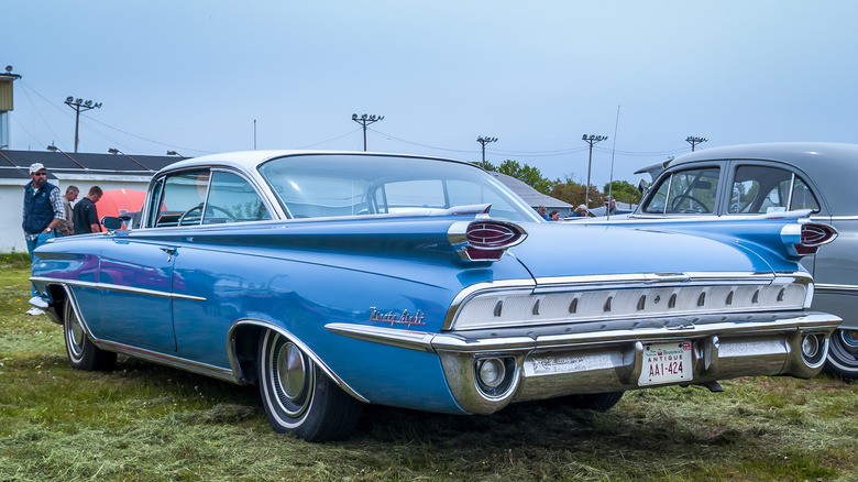 Blue Oldsmobile 98 parked on grass