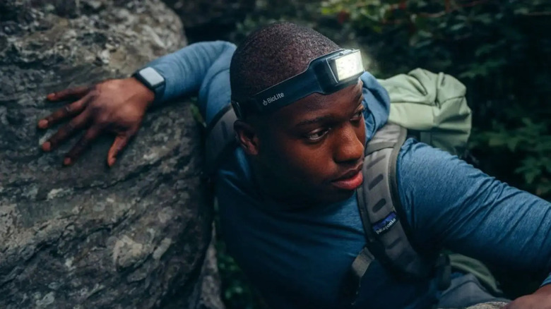 Man climbing on rock with headlamp on