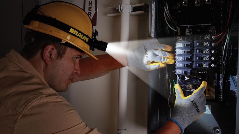 Man working on electrical box with headlamp on