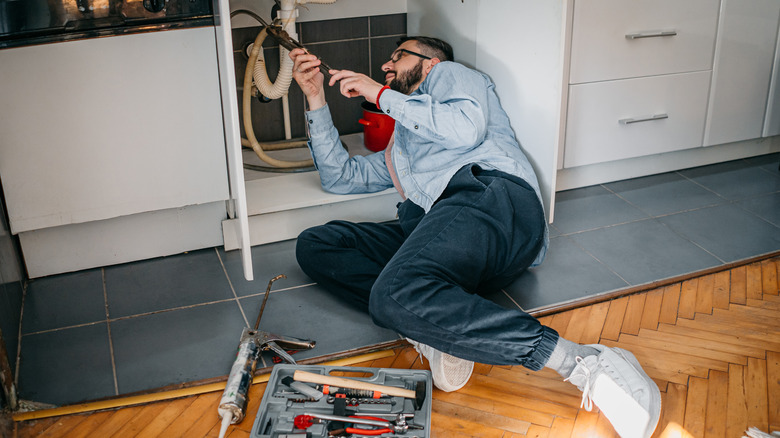 person working under sink