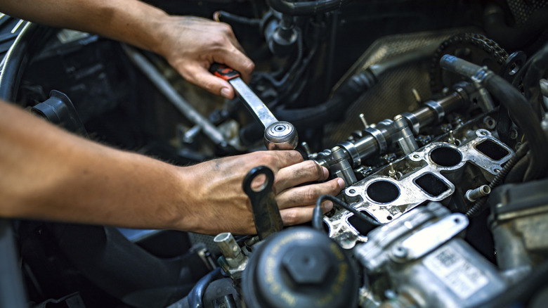 pair hands working on engine