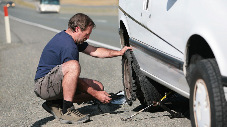 changing tire on side of road