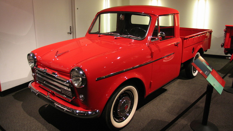 Red Datsun 220 pickup truck in museum display