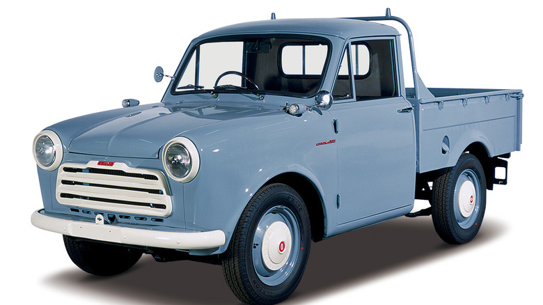 Blue Nissan 220 pickup against white background