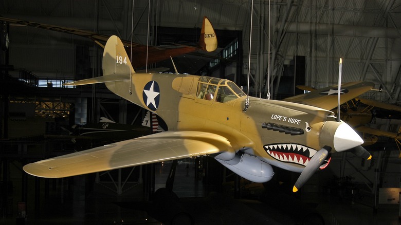 Curtis P-40 Warhawk with camouflage paint hanging from Smithsonian museum ceiling