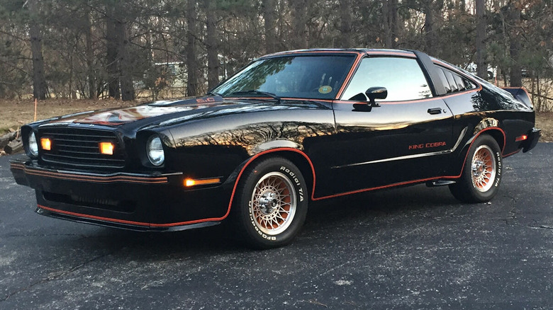 Black 1978 Mustang II King Cobra parked in driveway with trees in background