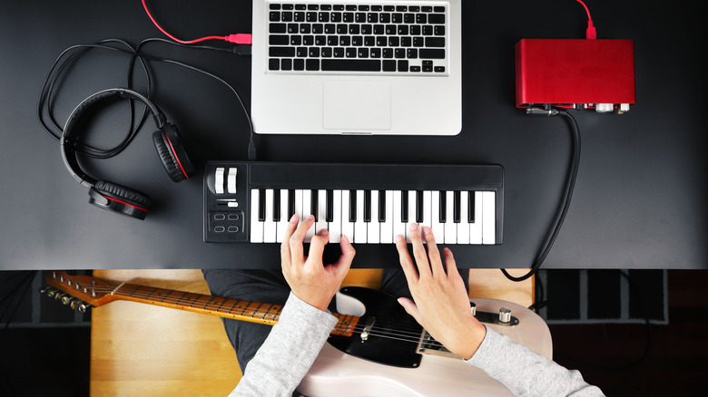 musician using MIDI keyboard with laptop