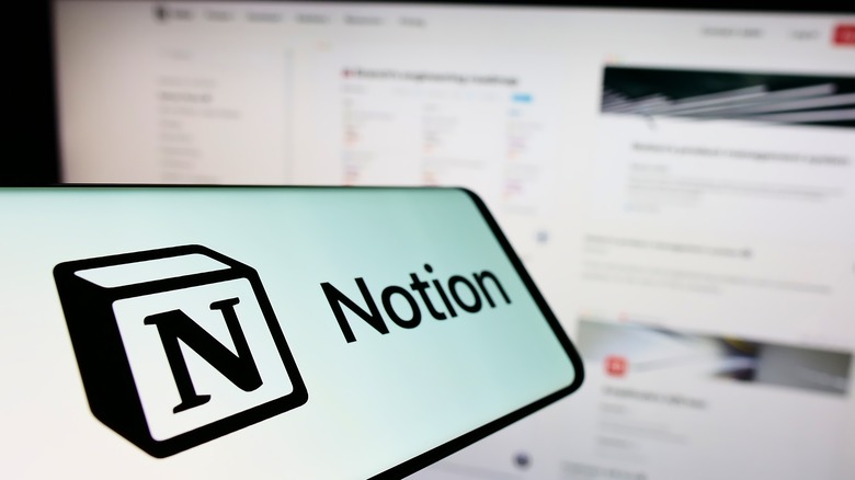 Notion app on phone in front of monitor