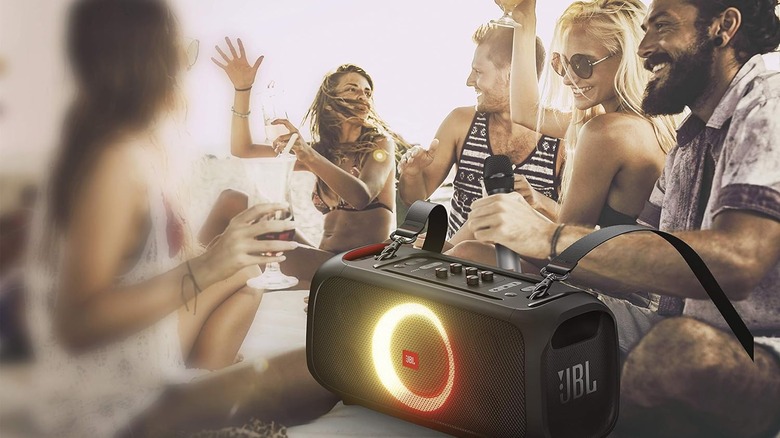 Friends use JBL speaker on beach