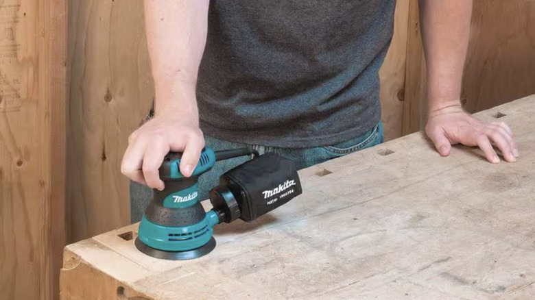 Person using a sander on wood