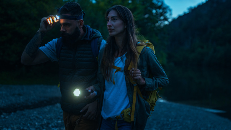 A couple hiking with flashlights