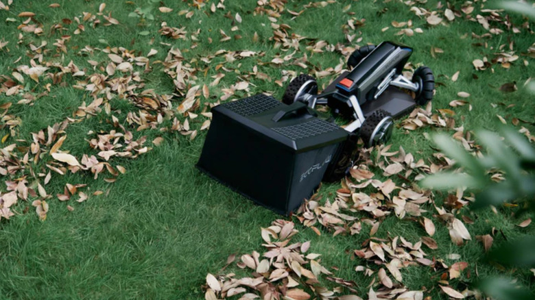 EcoFlow Blade with Sweeping Kit running across leafy lawn