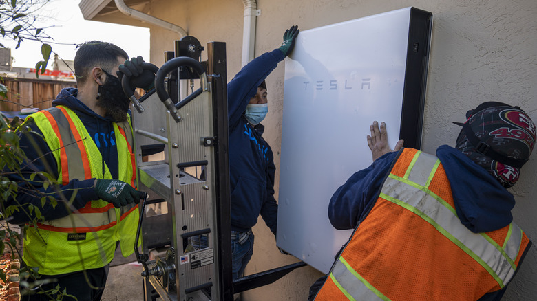 People installing a Tesla Powerwall