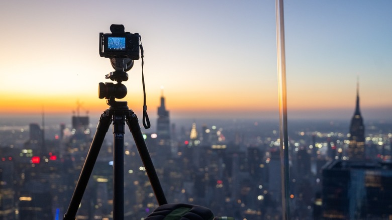 camera on tripod aimed at cityscape