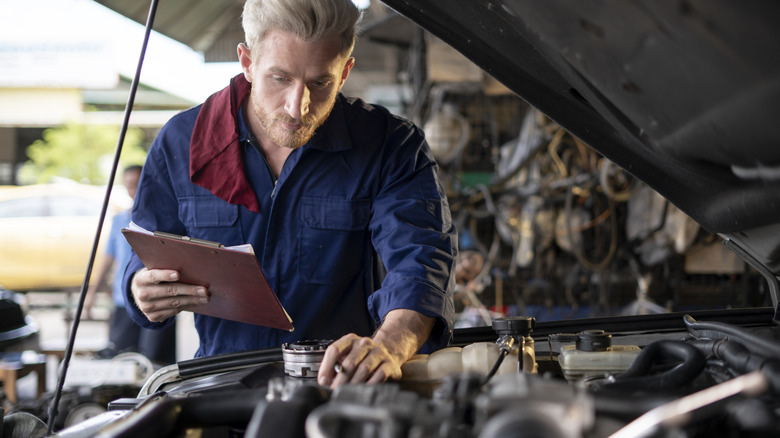 Mechanic looking under the hood of a car