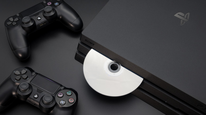 PS4 Pro with disc inserted and two DualShock controllers