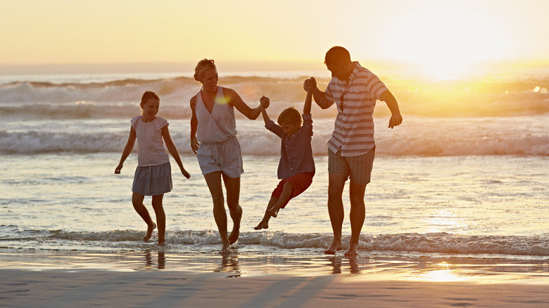 family on beach with sunset