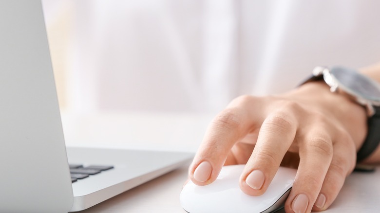 man using white wireless mouse