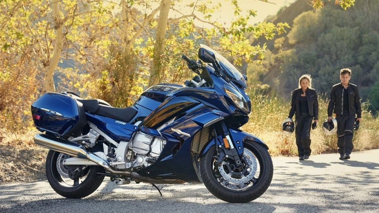 couple walking toward a Yamaha FJR1300