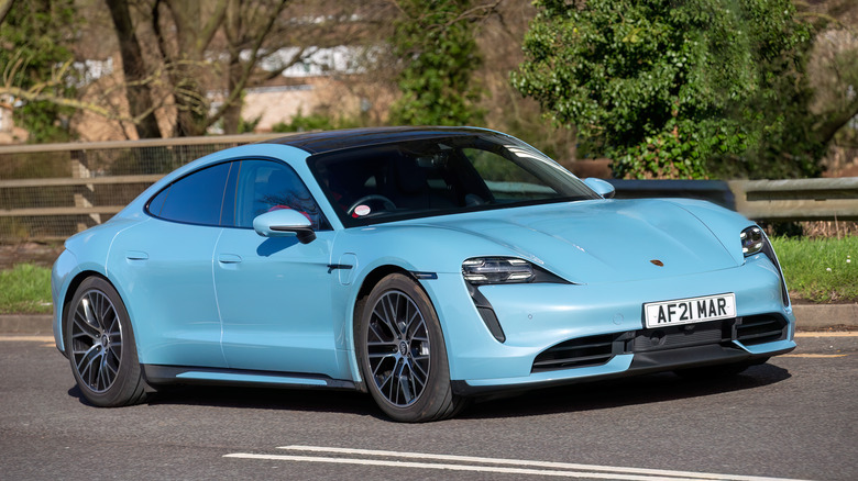 A blue Porsche Taycan running on the road