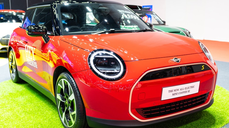 A red Mini Cooper SE displayed at an auto show