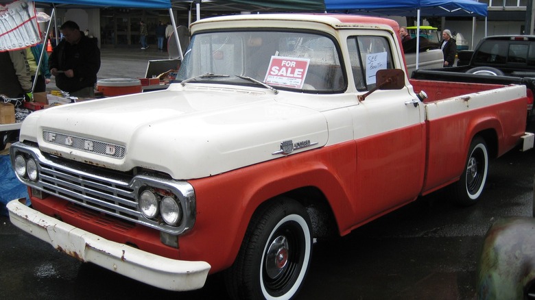 a two-tone 1957 Ford F-100 with a for sale sign