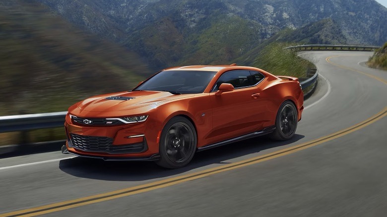 Orange Camaro speeding down a road