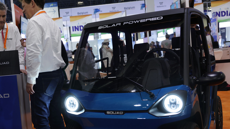 Men standing by Squad Solar City Car