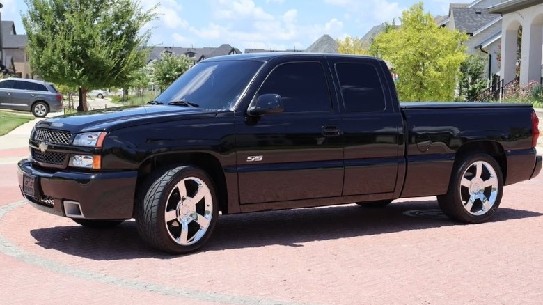 Black Chevrolet Silverado SS parked with trees and buildings in the background