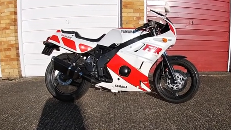 Red and white 1988 Yamaha FZR400 in front of garages