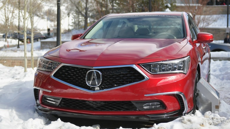 a red Acura RLX in the snow