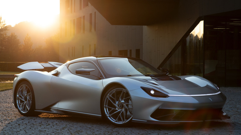 A silver Pininfarina Battista parked in driveway at sunset