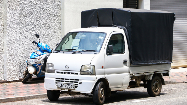 White Mazda Scrum carrying cargo