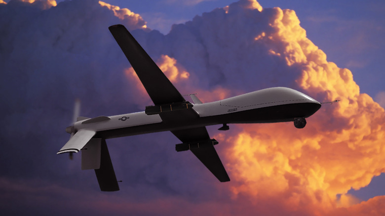 USAF General Atomics MQ-1 Predator Unmanned Aerial Vehicle (UAV) in sunset clouds carrying AGM-114 Hellfire air-to-ground missiles