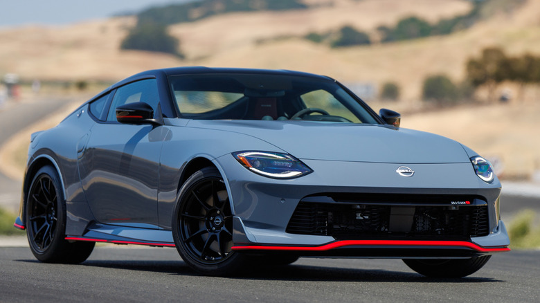 blue-grey Nissan Z Nismo parked on track with hills in background