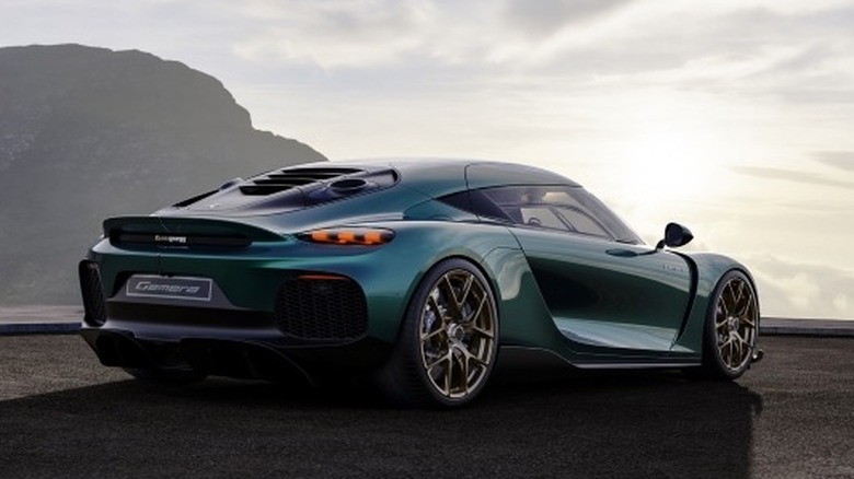 Green Koenigsegg Gemera parked on a pavement with sky background