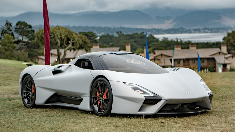 SSC Tuatara parked on grass with trees and buildings in the background