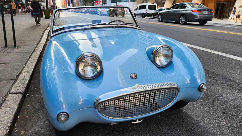 Blue Frogeye Sprite smiling while parked on the street