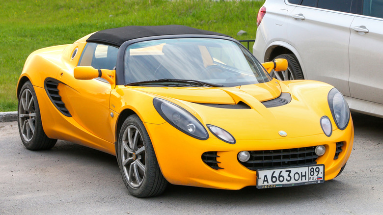 Yellow Lotus Elise smiling in parking lot