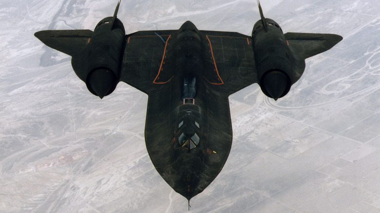 A camouflage-painted SR-71 flies over a desert