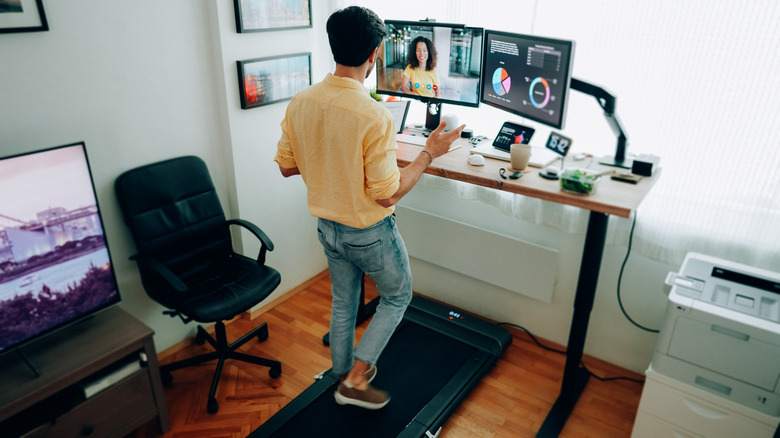 man working and using desk treadmill