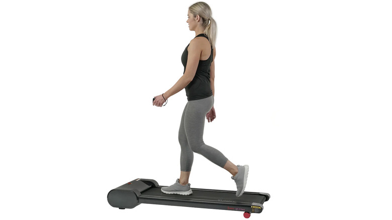 woman using Sunny Health & Fitness Slim Work Office Treadmill