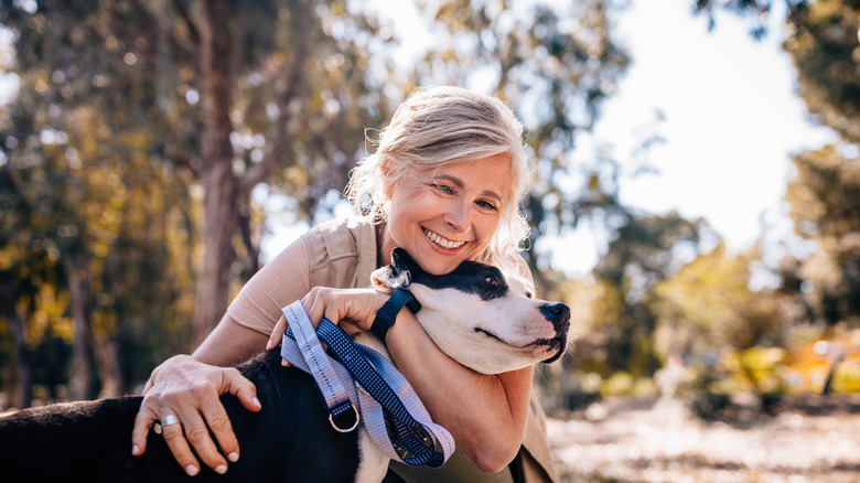 elderly woman hugging dog