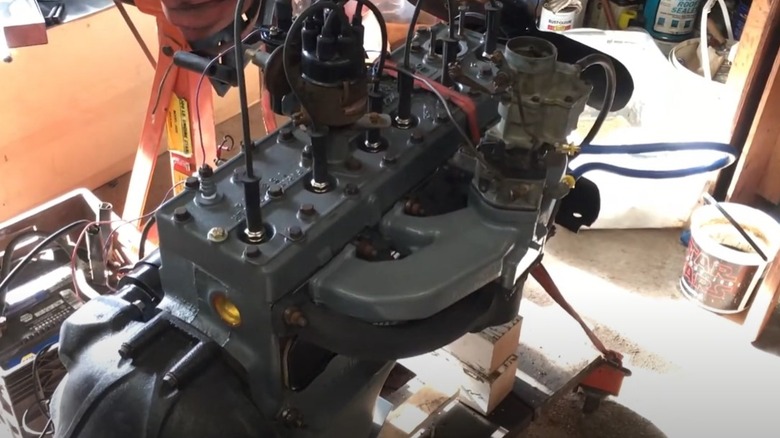 Willys Super Hurricane Engine on a stand in a garage